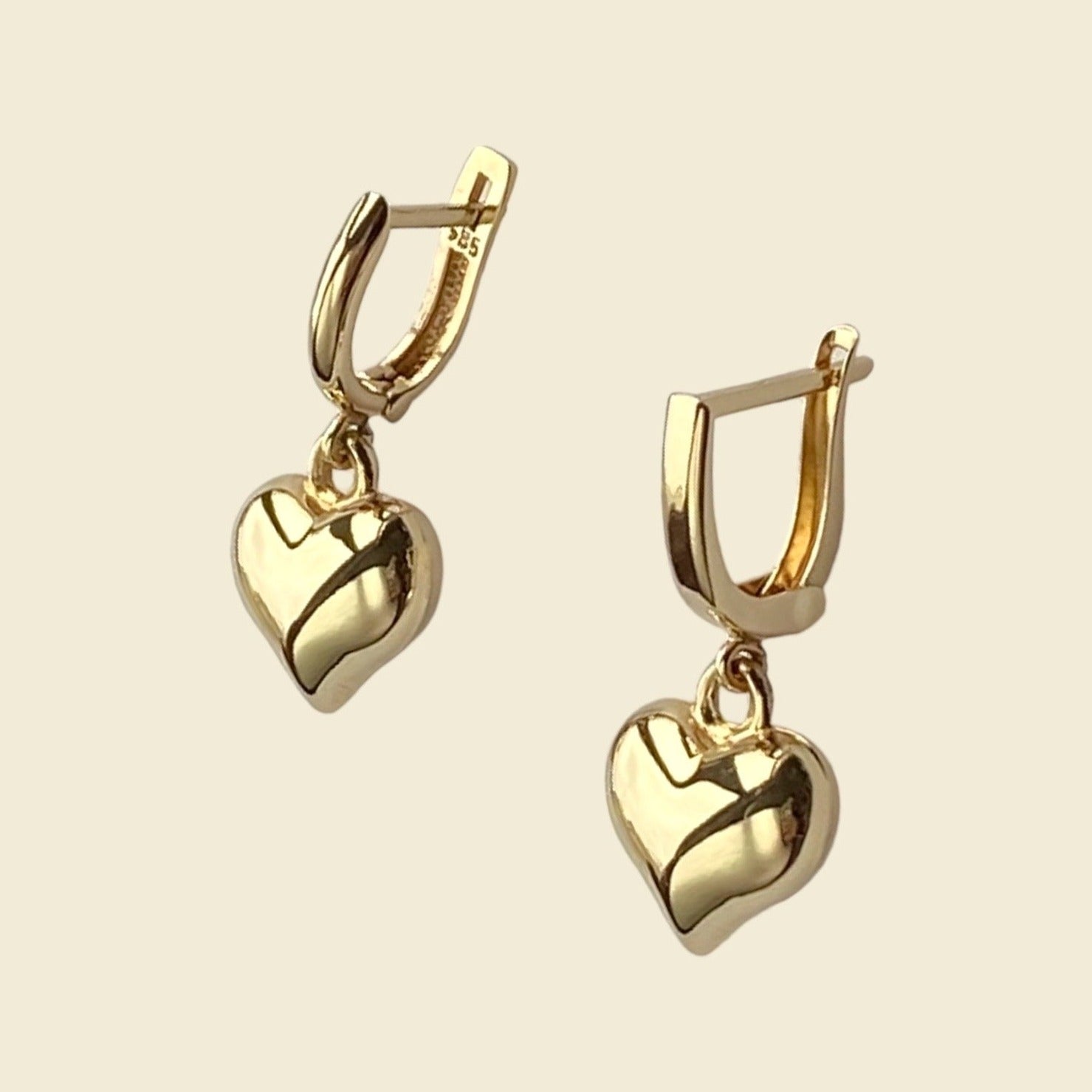Aurora is handcrafted using only 14 karat solid gold, featuring a puffy heart pendant on hinged closure mini hoop. 