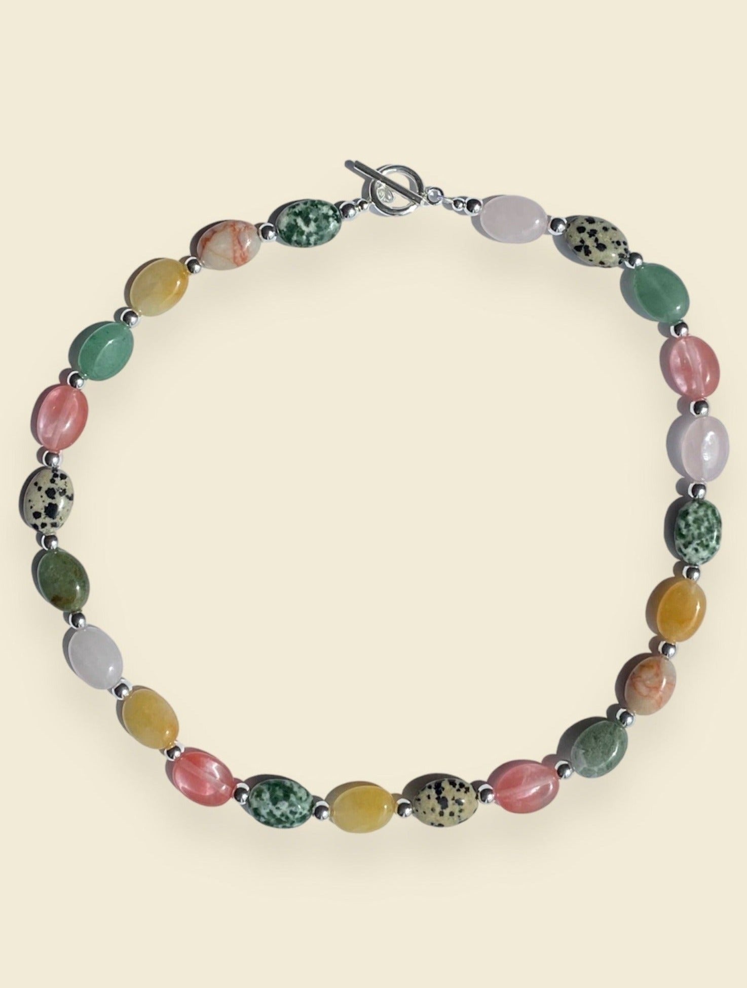 Estelle is a choker style necklace with aventurine, quartz, dalmatian jasper, hematite and jade gemstones and 923 sterling silver toggle bar.