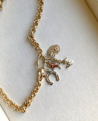 Gold chain necklace with charms on a light background